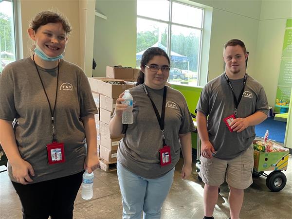 Image of three students helping at the Journey food distribution